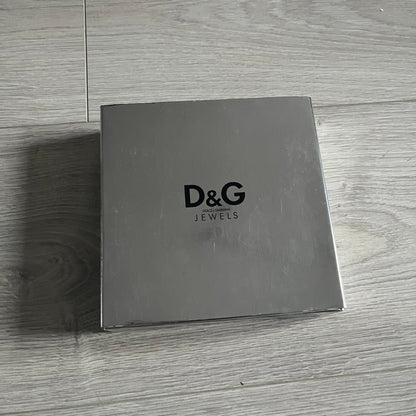 Dolce & Gabbana Pearl Brown Rosary Necklace from the 2000s era. The necklace features a silver-tone metal cross with a D&G logo, connected via a black leather link to a metal chain with alternating brown and yellow pearl-style beads. Rosary-style construction with mixed materials including metal, leather, and resin pearls. Comes complete with the original box.