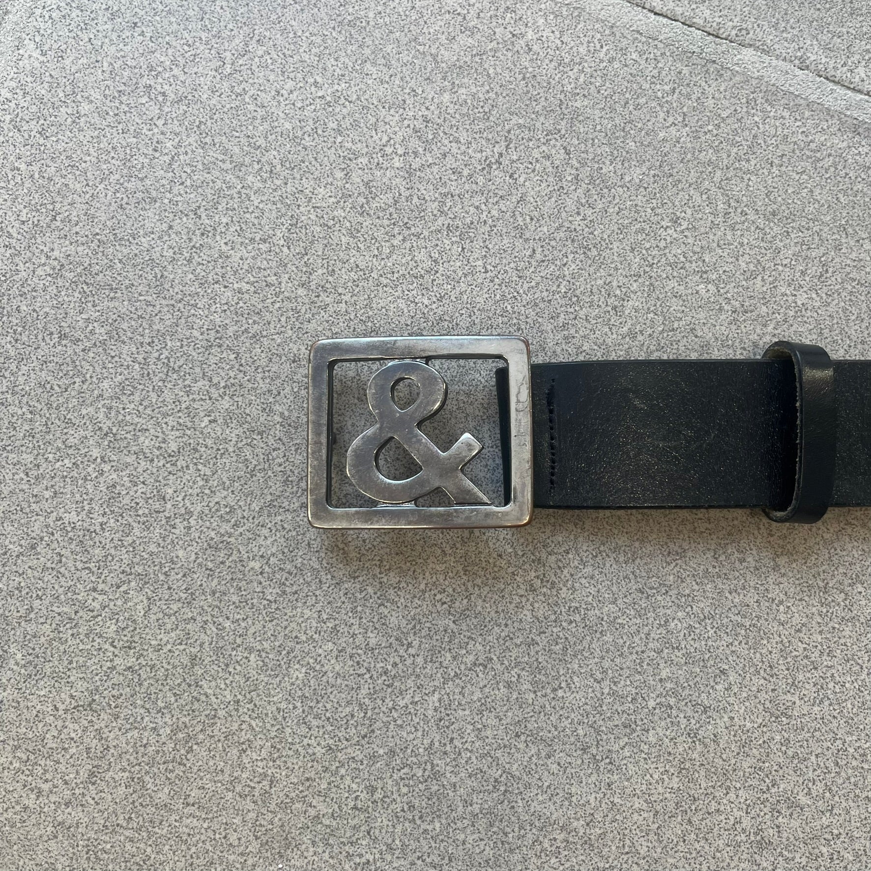  Dolce &amp; Gabbana 2000s Ampersand Black Belt features a black leather strap with a metal ampersand-shaped buckle set inside a square outline. Made in Italy. 