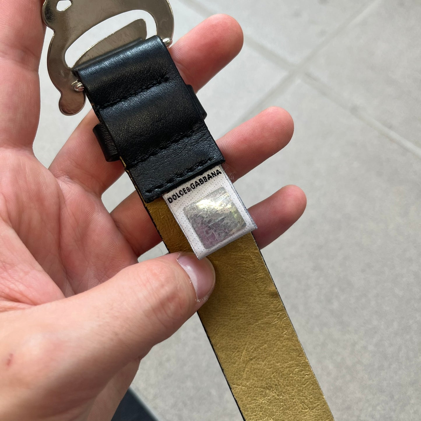 Dolce &amp; Gabbana 2000s Black Crystal Buckle Belt features a black leather strap with a stainless steel D&amp;G logo buckle. The buckle has a decorative italic-style font and is fully covered with crystal/rhinestone detailing on the front. Made in Italy.