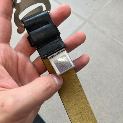 Dolce &amp; Gabbana 2000s Black Crystal Buckle Belt features a black leather strap with a stainless steel D&amp;G logo buckle. The buckle has a decorative italic-style font and is fully covered with crystal/rhinestone detailing on the front. Made in Italy.