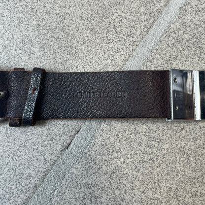 Dolce & Gabbana 2000's Brown Leather Bracelet features brown leather straps with an adjustable fit and a stainless steel central plaque. The plaque has a raised wavy texture on the front and a D&G logo underneath, while the leather straps have small D&G and “Genuine Leather” tags.
