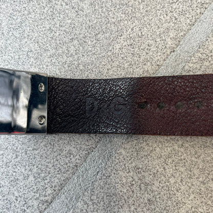 Dolce & Gabbana 2000's Brown Leather Bracelet features brown leather straps with an adjustable fit and a stainless steel central plaque. The plaque has a raised wavy texture on the front and a D&G logo underneath, while the leather straps have small D&G and “Genuine Leather” tags.
