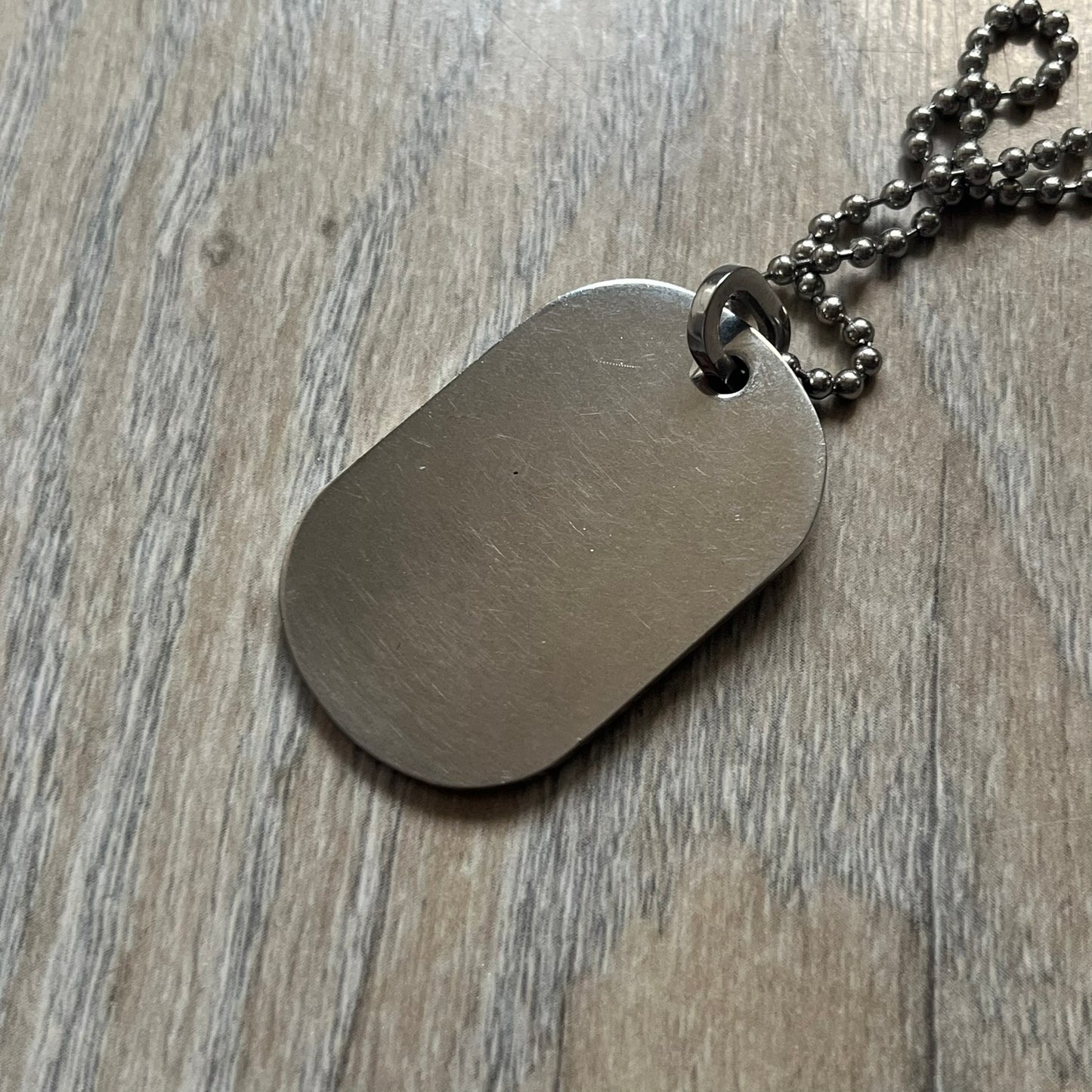 Dolce &amp; Gabbana Cowboy Dog Tag Necklace, model DJ0633. Features a silver-tone metal ball chain and a dog tag with black cowboy-style D&amp;G logo and small “Dolce &amp; Gabbana” text underneath. The front of the tag is patterned with subtle white dots for added detail.