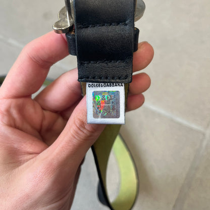 Dolce &amp; Gabbana 2000s Black Crystal Buckle Belt features a black leather strap with a stainless steel D&amp;G logo buckle. The buckle has a decorative italic-style font and is fully covered with crystal/rhinestone detailing on the front. Made in Italy.