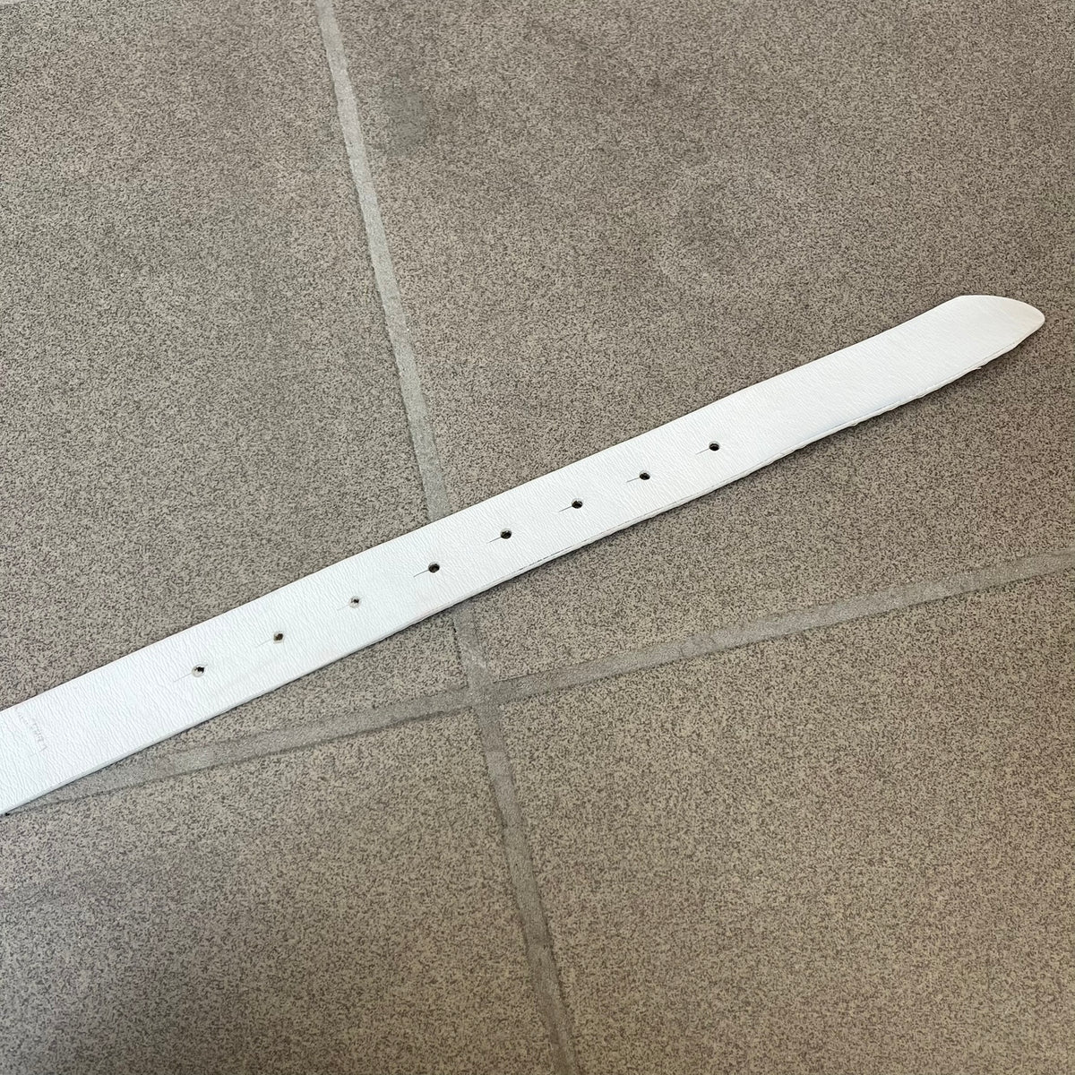 Dolce &amp; Gabbana 2000's Crystal Buckle White Belt features a white leather strap with a stainless steel D&amp;G logo buckle. The buckle has a decorative italic-style font and is fully covered with crystal/rhinestone detailing on the front. Made in Italy.