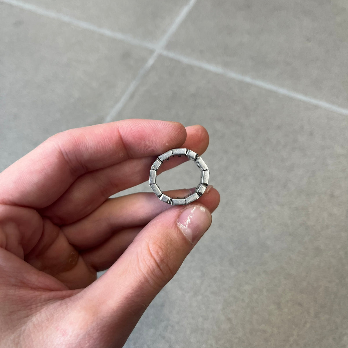 Dolce & Gabbana 2000's Crystal Overlap Ring is a stainless steel ring constructed entirely from cutout D&G letters, forming four repeating D&G sets across 12 letters, each covered in crystals. The ring has slight elasticity, with the letters held together internally by strings.