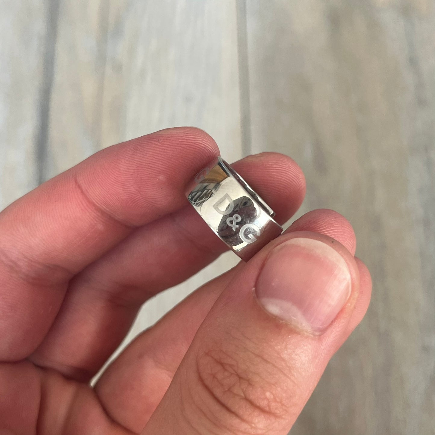 Dolce &amp; Gabbana DJ0404 D&amp;G Logo Earrings are a pair of 2000s silver-tone hoop earrings with a wide profile. The earrings feature an engraved repeating D&amp;G logo around the outer surface. They have a hinged hoop design with a straight post closure and a polished metal finish.