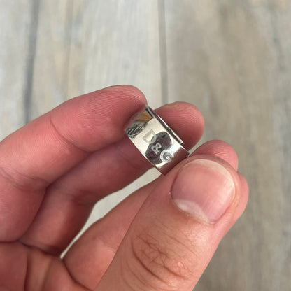Dolce &amp; Gabbana DJ0404 D&amp;G Logo Earrings are a pair of 2000s silver-tone hoop earrings with a wide profile. The earrings feature an engraved repeating D&amp;G logo around the outer surface. They have a hinged hoop design with a straight post closure and a polished metal finish.