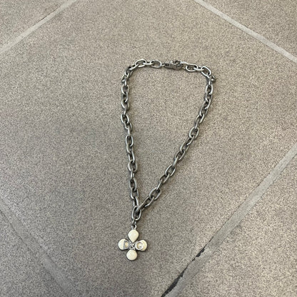 Dolce &amp; Gabbana DJ0879 Four-Leaf Clover Necklace is a stainless steel necklace with a clover pendant that has a stainless steel back and a 3D light beige/cream enamel front. A raised steel D&amp;G logo sits on the front. The oval-link chain alternates between smooth and textured links
