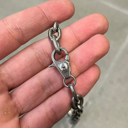 Dolce &amp; Gabbana DJ0879 Four-Leaf Clover Necklace is a stainless steel necklace with a clover pendant that has a stainless steel back and a 3D light beige/cream enamel front. A raised steel D&amp;G logo sits on the front. The oval-link chain alternates between smooth and textured links