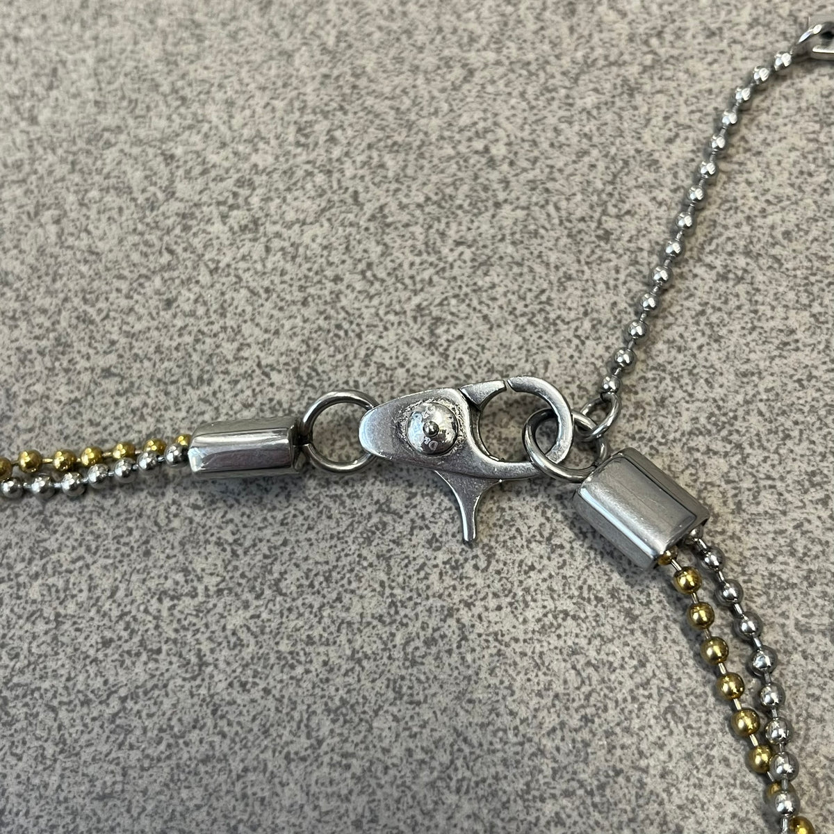 Dolce &amp; Gabbana 2000's Gold Heart DJ0637 Necklace features a stainless steel ball &nbsp;chain, one in silver-tone, the second in gold-tone, with a dog tag-style pendant. The pendant is engraved with a subtle "I" above a gold-tone heart secured by three visible screws, with "D&amp;G" engraved below to form the "I ❤️ D&amp;G" design.&nbsp;