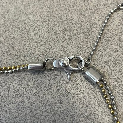 Dolce &amp; Gabbana 2000's Gold Heart DJ0637 Necklace features a stainless steel ball &nbsp;chain, one in silver-tone, the second in gold-tone, with a dog tag-style pendant. The pendant is engraved with a subtle "I" above a gold-tone heart secured by three visible screws, with "D&amp;G" engraved below to form the "I ❤️ D&amp;G" design.&nbsp;
