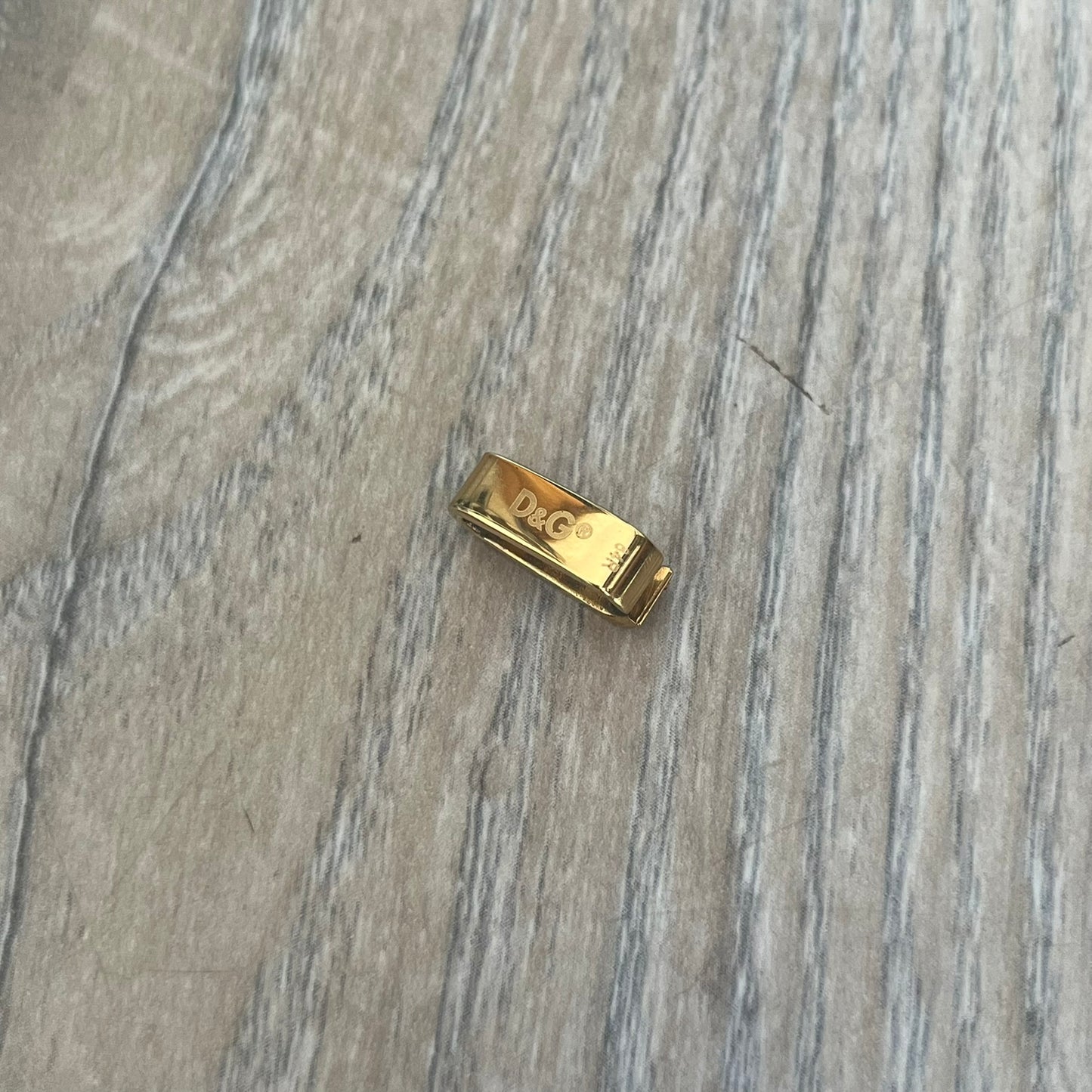 Dolce & Gabbana DJ0680 Gold Rings Set is a 2000s set consisting of four gold-tone rings. Each ring can be worn individually or connected together using the included square D&G clip to form a single four-ring design. The rings have a simple polished finish and come with the original tags.
