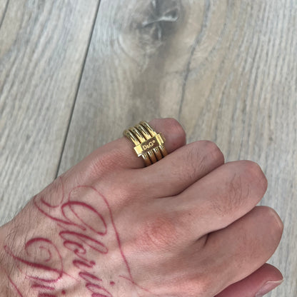 Dolce & Gabbana DJ0680 Gold Rings Set is a 2000s set consisting of four gold-tone rings. Each ring can be worn individually or connected together using the included square D&G clip to form a single four-ring design. The rings have a simple polished finish and come with the original tags.
