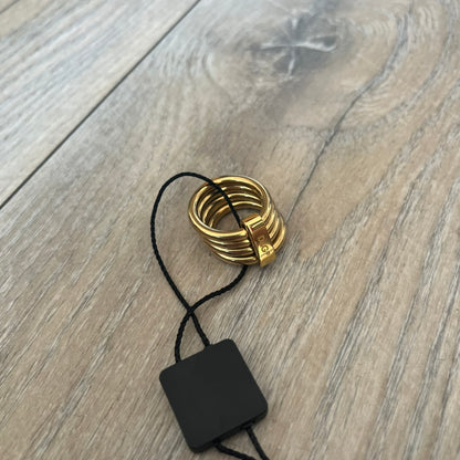 Dolce & Gabbana DJ0680 Gold Rings Set is a 2000s set consisting of four gold-tone rings. Each ring can be worn individually or connected together using the included square D&G clip to form a single four-ring design. The rings have a simple polished finish and come with the original tags.
