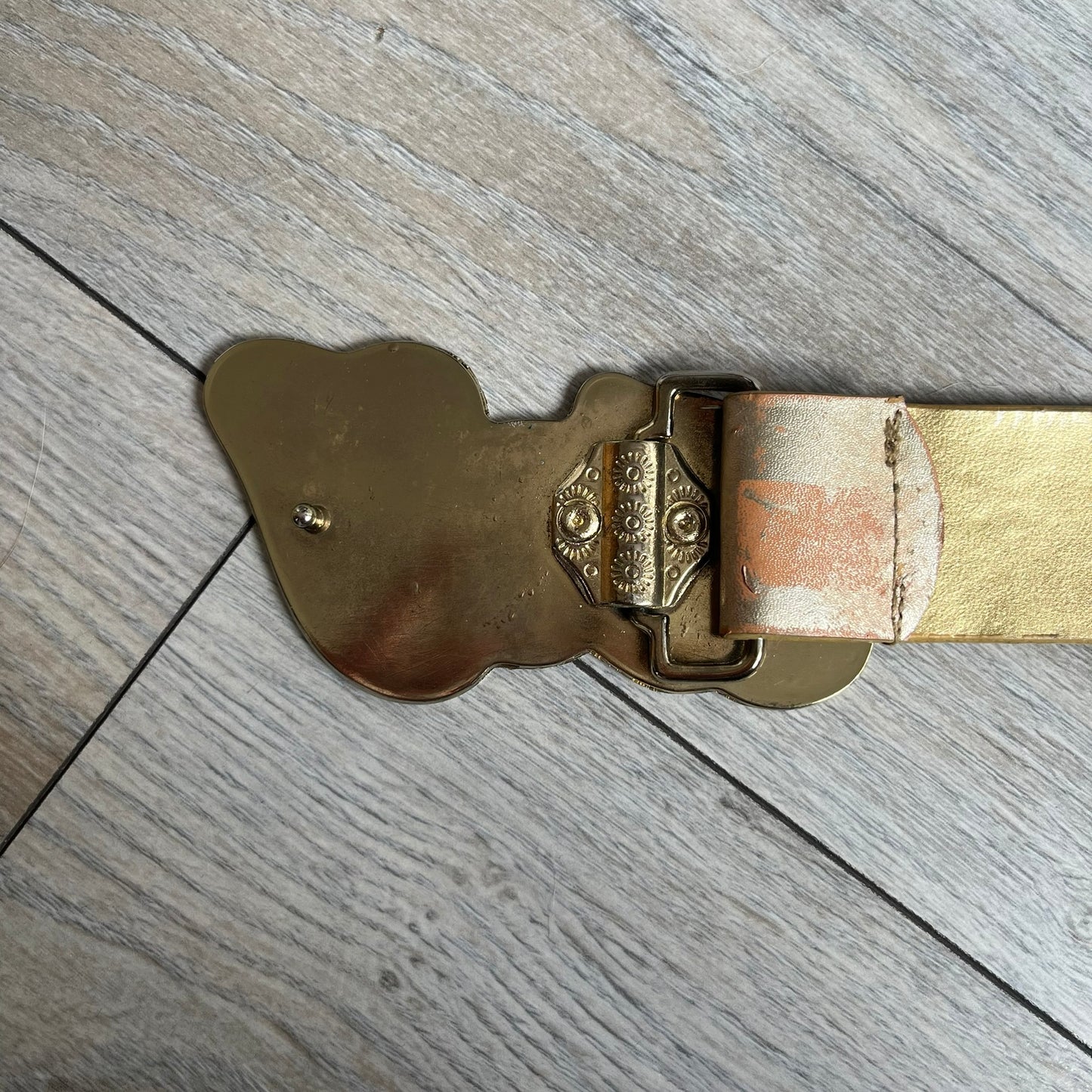 The Dolce &amp; Gabbana 2000’s Gold Tone D&amp;G Logo Belt is made from metallic gold leather and features a large D&amp;G logo buckle shaped directly as the brand’s initials. The buckle uses a cursive D&amp;G logo set over a glittery gold background, framed by a solid gold-tone metal outline. The entire buckle and belt maintain a consistent gold color scheme typical of Dolce &amp; Gabbana accessories from the 2000s.