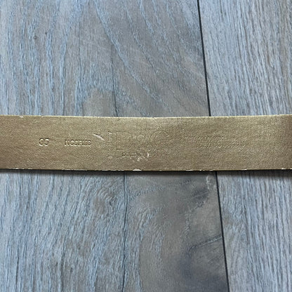 The Dolce & Gabbana 2000’s Gold Tone D&G Logo Belt is made from metallic gold leather and features a large D&G logo buckle shaped directly as the brand’s initials. The buckle uses a cursive D&G logo set over a glittery gold background, framed by a solid gold-tone metal outline. The entire buckle and belt maintain a consistent gold color scheme typical of Dolce & Gabbana accessories from the 2000s.