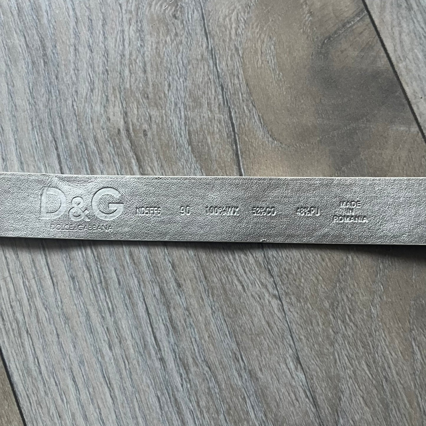 Archive Dolce &amp; Gabbana belt from the 2000s featuring a pretty big metal apple-shaped buckle with a leaf detail, finished in green with silver accents and a small D&amp;G logo. The belt is crafted from white leather with a silver-toned interior, includes a small metal D&amp;G logo at the tip, and is marked Made in Romania. Comes with original tags; the oversized buckle contrasts with the slim belt width.