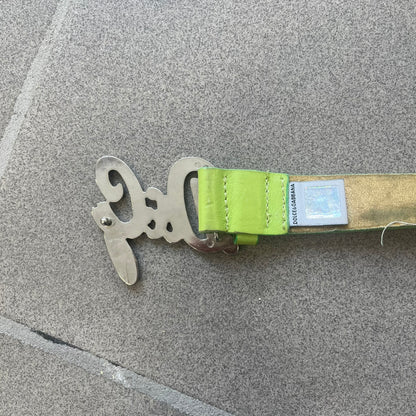 Dolce &amp; Gabbana 2000s Green Crystal Buckle Belt features a lime green leather strap with a stainless steel D&amp;G logo buckle. The buckle has a decorative italic-style font and is fully covered with crystal/rhinestone detailing on the front. Made in Italy.