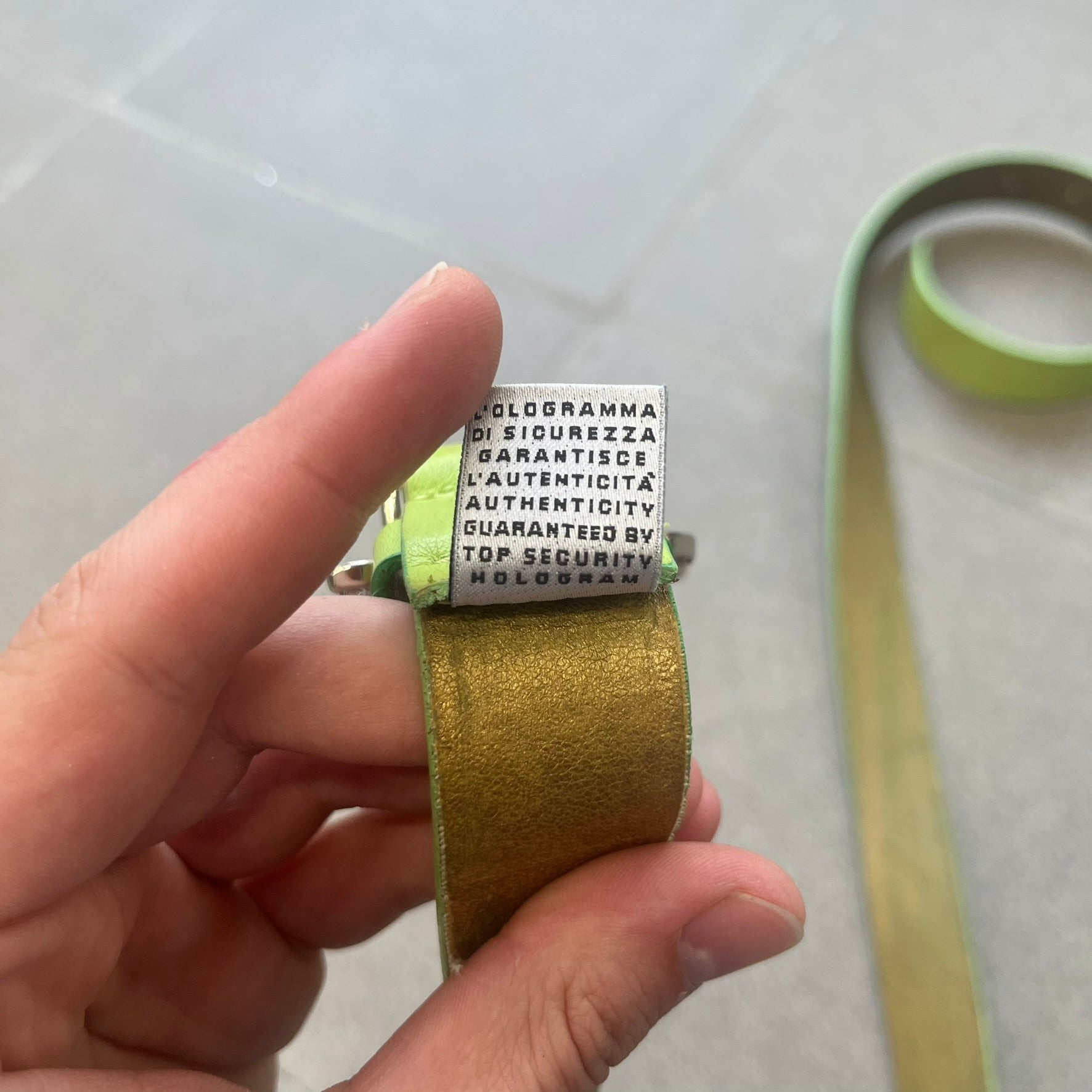 Dolce &amp; Gabbana 2000s Green Crystal Buckle Belt features a lime green leather strap with a stainless steel D&amp;G logo buckle. The buckle has a decorative italic-style font and is fully covered with crystal/rhinestone detailing on the front. Made in Italy.