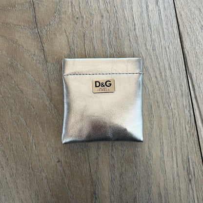 Dolce & Gabbana DJ1013 2000s Heart Earrings feature a silver-tone dangling design with D&G logo studs at the top and large outlined heart charms suspended below. The heart pendants are movable and hang freely from the logo attachment. The earrings come with the original Dolce & Gabbana dust bag.