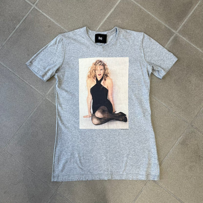 Dolce &amp; Gabbana 2000's Kim Basinger Tee is a gray T-shirt with a photo of Kim Basinger on the front and small “Herb Ritts Foundation” text below it. The lower back has D&amp;G text logo. The shirt is constructed inside-out style, with the stitching visible along the sides.