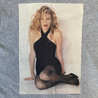 Dolce &amp; Gabbana 2000's Kim Basinger Tee is a gray T-shirt with a photo of Kim Basinger on the front and small “Herb Ritts Foundation” text below it. The lower back has D&amp;G text logo. The shirt is constructed inside-out style, with the stitching visible along the sides.
