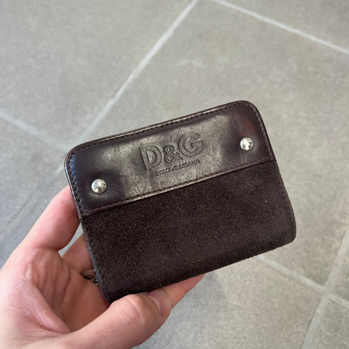 Dolce & Gabbana 2000's Leather Chain Wallet is made in Italy from a combination of suede and shiny leather, featuring two visible screw details and a D&G logo on the leather portion. The interior includes two pockets and a leather tag, with an attached chain.