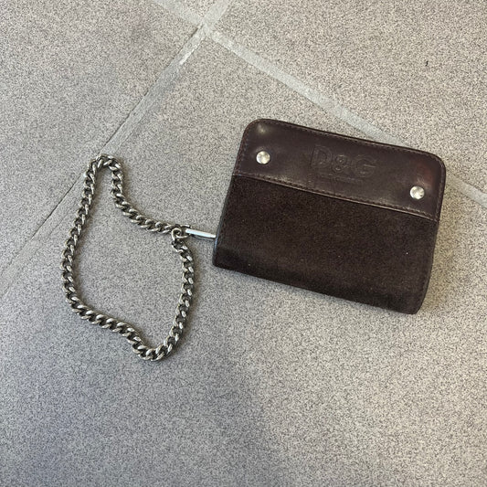 Dolce & Gabbana 2000's Leather Chain Wallet is made in Italy from a combination of suede and shiny leather, featuring two visible screw details and a D&G logo on the leather portion. The interior includes two pockets and a leather tag, with an attached chain.
