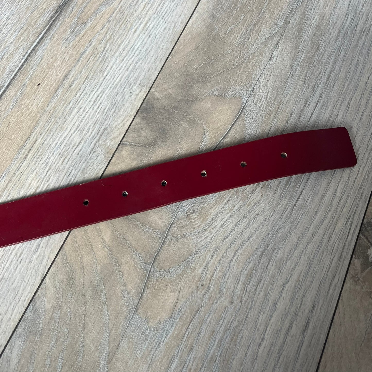 Dolce & Gabbana 2000s Moto Biker Leather Belt is a dark red leather belt made in Italy. The bronze-tone buckle features blue and red enamel detailing, with a biker graphic in the center on a red background. Above the rider is “GOD SAVE THE RIDER” text on a blue background. The buckle is finished with star detailing. Made from 100% leather.
