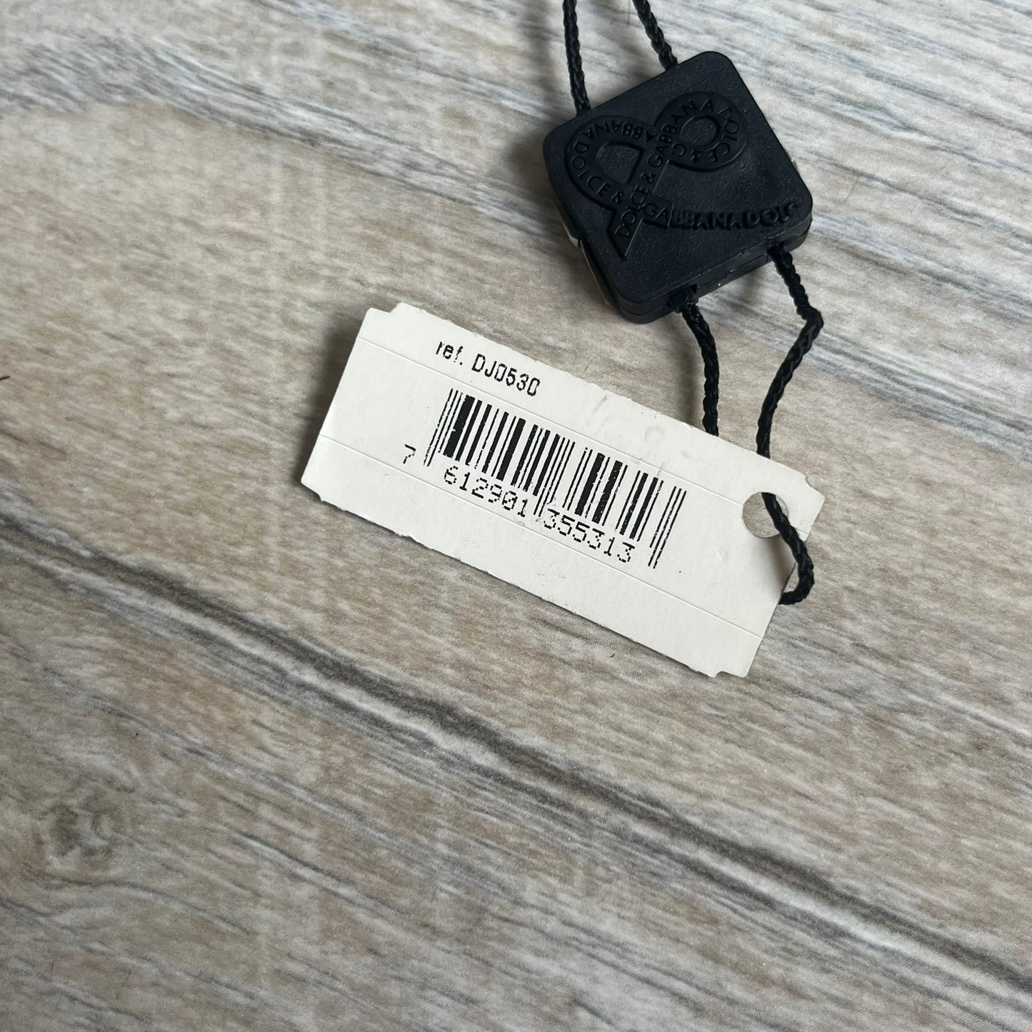 Dolce & Gabbana 2000s Overlap Logo Necklace DJ0530 is a necklace featuring a pendant with overlapping D&G letter cutouts in a slightly raised 3D design. The back of the pendant is flat with a small engraved D&G logo. It is attached to an adjustable cord chain with a regulator closure.
