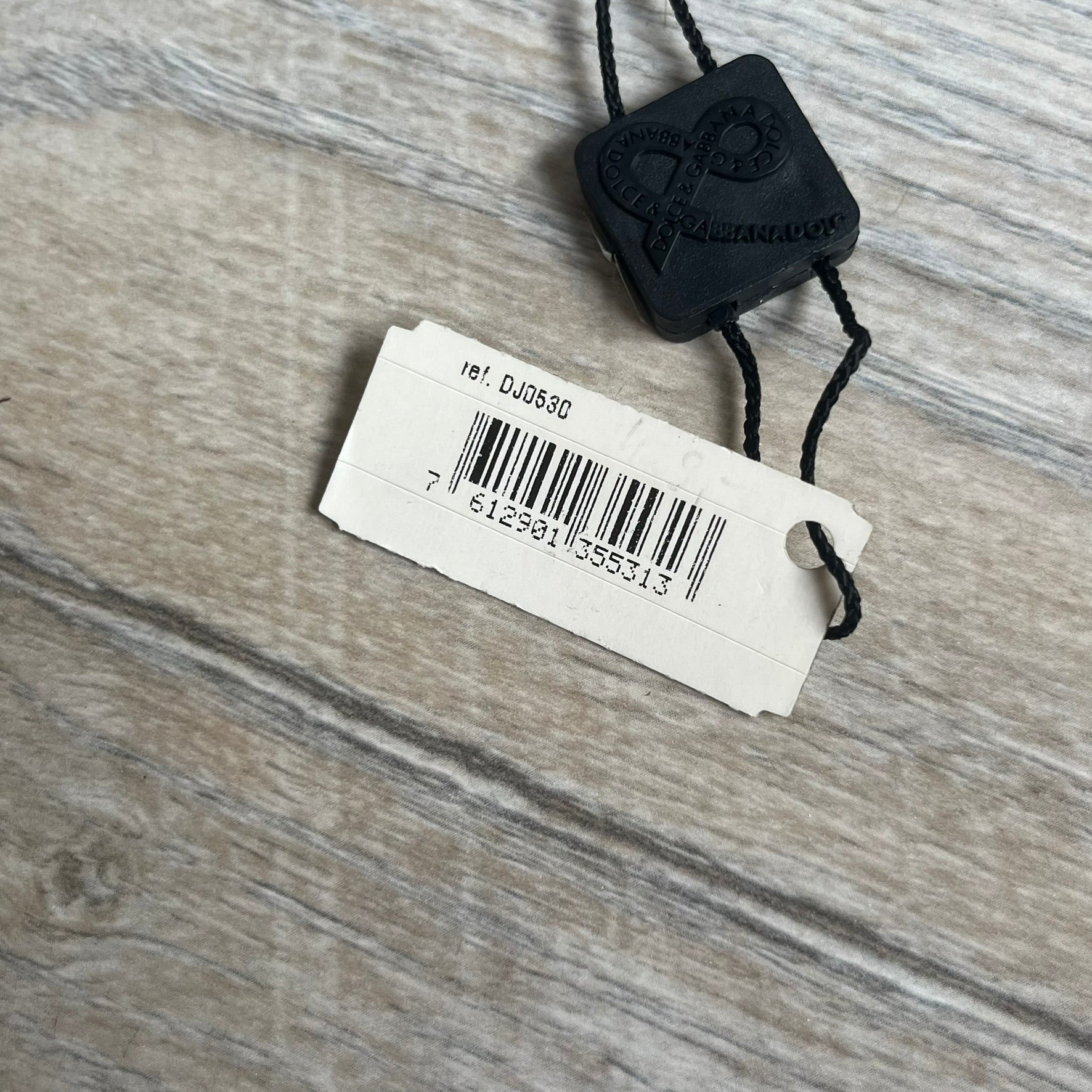 Dolce & Gabbana 2000s Overlap Logo Necklace DJ0530 is a necklace featuring a pendant with overlapping D&G letter cutouts in a slightly raised 3D design. The back of the pendant is flat with a small engraved D&G logo. It is attached to an adjustable cord chain with a regulator closure.

