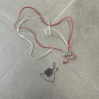 Dolce &amp; Gabbana 2000s Red &amp; White Strings Necklace &amp; Bracelet is a versatile accessory featuring red and white leather cords joined with stainless steel end caps. The center is finished with a stainless steel D&amp;G logo, while the back of the logo features a small engraved D&amp;G mark. Designed to be worn either as a necklace or wrapped as a bracelet.