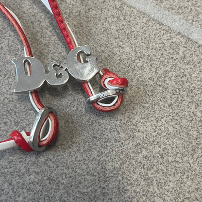 Dolce &amp; Gabbana 2000s Red &amp; White Strings Necklace &amp; Bracelet is a versatile accessory featuring red and white leather cords joined with stainless steel end caps. The center is finished with a stainless steel D&amp;G logo, while the back of the logo features a small engraved D&amp;G mark. Designed to be worn either as a necklace or wrapped as a bracelet.