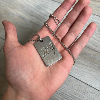 Dolce &amp; Gabbana Rhinestones Dog Tag Necklace DJ0704 crafted from polished stainless steel. Features a rectangular pendant with the iconic D&amp;G logo detailed in rhinestones, and “Dolce &amp; Gabbana” engraved subtly below. Comes with a basic non-D&amp;G steel ball chain.