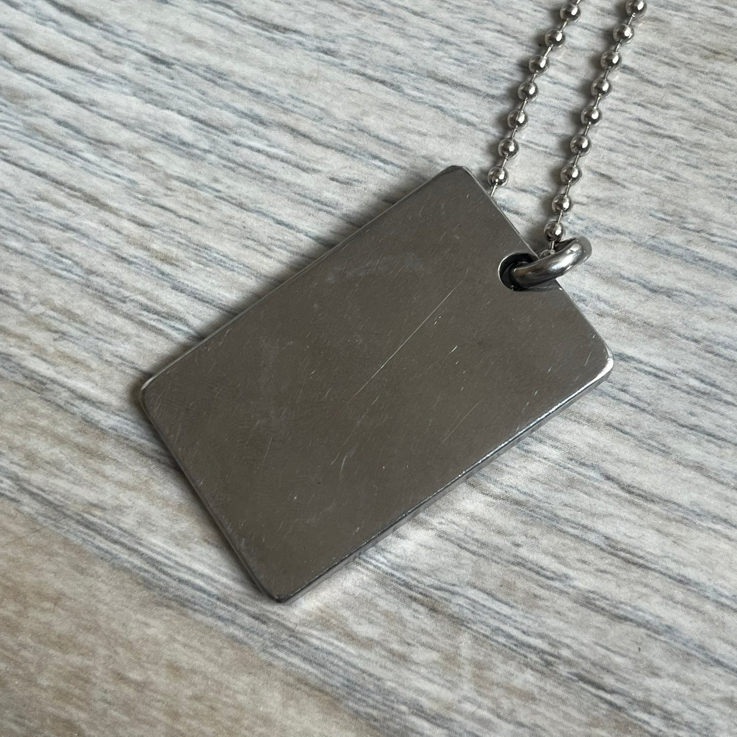Dolce &amp; Gabbana Rhinestones Dog Tag Necklace DJ0704 crafted from polished stainless steel. Features a rectangular pendant with the iconic D&amp;G logo detailed in rhinestones, and “Dolce &amp; Gabbana” engraved subtly below. Comes with a basic non-D&amp;G steel ball chain.