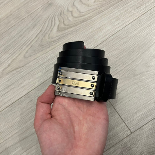 Dolce &amp; Gabbana 2000s Silver/Gold Bars Belt crafted from black leather with a solid metal buckle plate. The buckle features three horizontal metal bars secured with visible screws, with silver-tone bars on the top and bottom and a gold-tone center bar engraved with the D&amp;G logo. Finished with a structured leather strap, comes with the original dustbag.