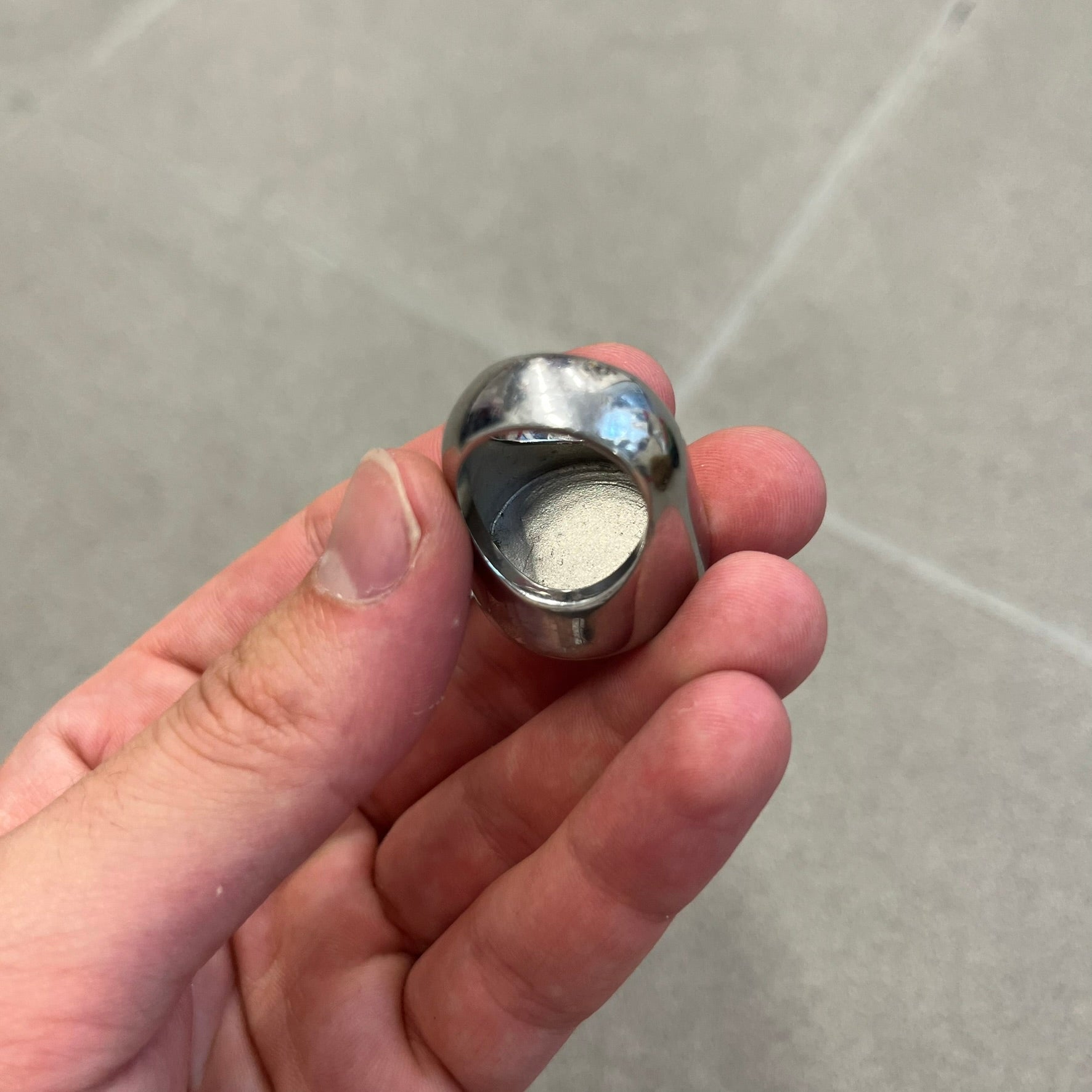 The Dolce &amp; Gabbana Silver Logo Signet Ring is a silver-tone metal signet ring with a thick, substantial design. The top features a beige background with the D&amp;G logo in silver tone, outlined in silver. The signet is large and solid.
