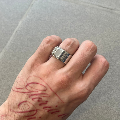 Dolce &amp; Gabbana DJ0836 Ring is made from silver-tone metal and features three raised square elements set across the top. Next to the squares, there is a small engraved D&amp;G logo. The ring has a clean, minimal design and is marked with model code DJ0836.