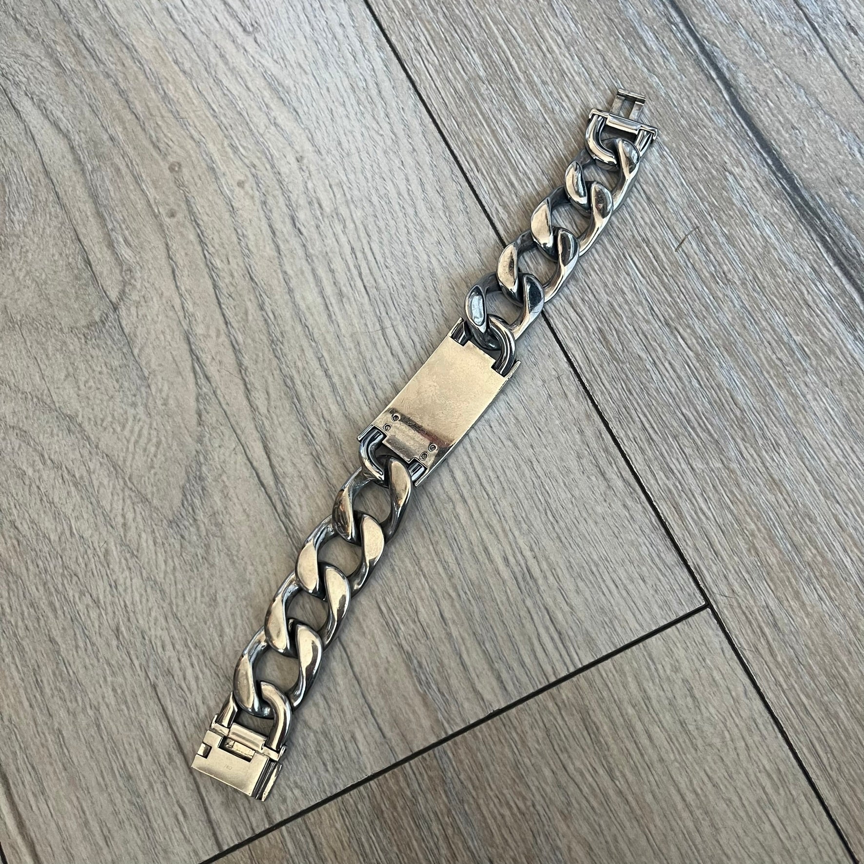 Dolce & Gabbana 2000’s Stainless Steel Bracelet DJ0552 is a thick bracelet made from stainless steel featuring large Cuban-style links. The center includes a plaque with a small engraved D&G logo, while the clasp is also marked with Dolce & Gabbana branding. The piece is referenced as DJ0552 and comes with the original box and dustbag.
