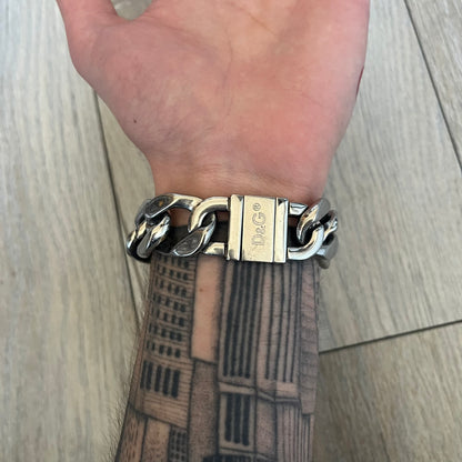 Dolce & Gabbana 2000’s Stainless Steel Bracelet DJ0552 is a thick bracelet made from stainless steel featuring large Cuban-style links. The center includes a plaque with a small engraved D&G logo, while the clasp is also marked with Dolce & Gabbana branding. The piece is referenced as DJ0552 and comes with the original box and dustbag.