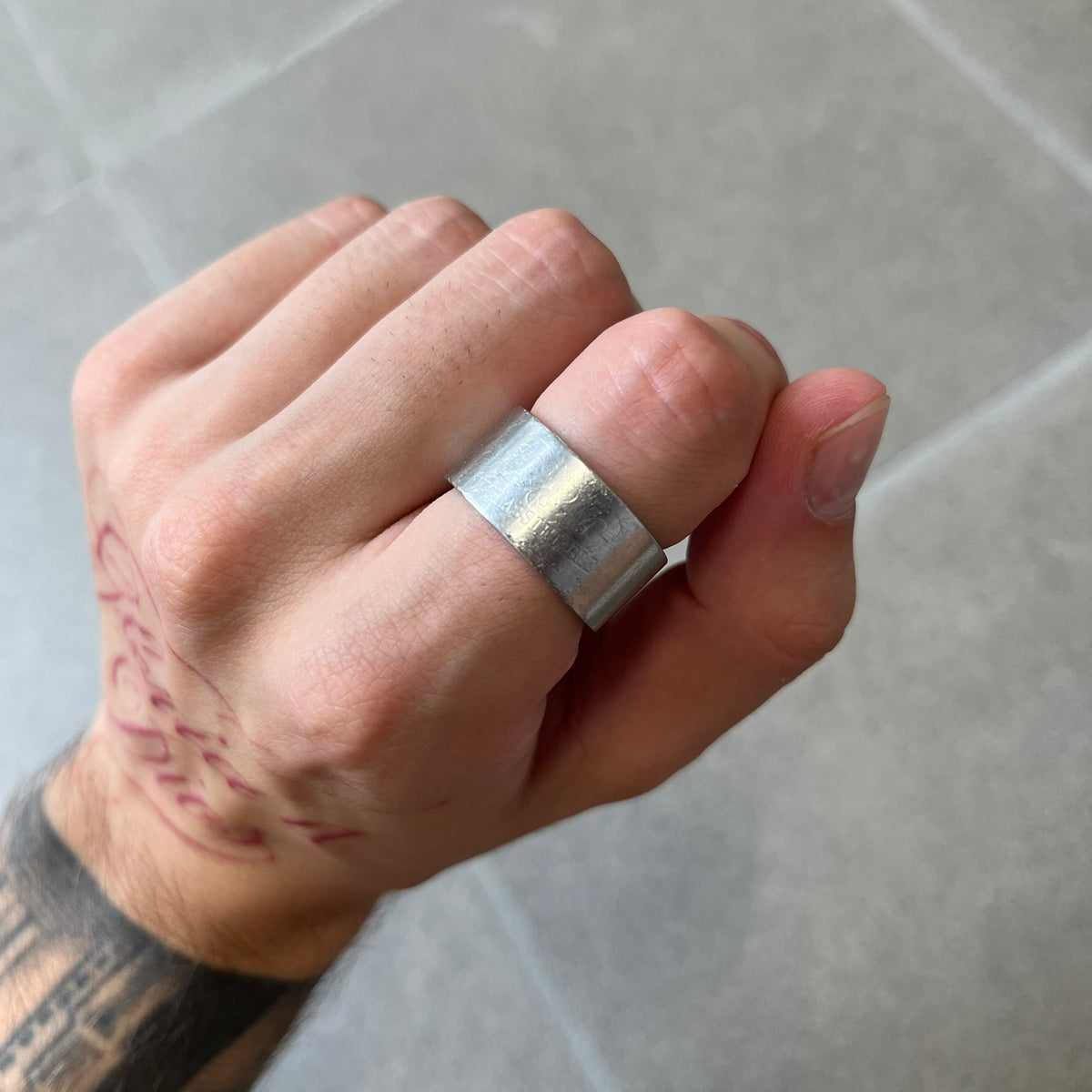 Dolce & Gabbana 2000's Unclassifiable Ring features a minimal stainless steel design with an engraved D&G logo and tilted “Unclassifiable” text underneath on the front. The model number and D&G branding are engraved on the inside.
