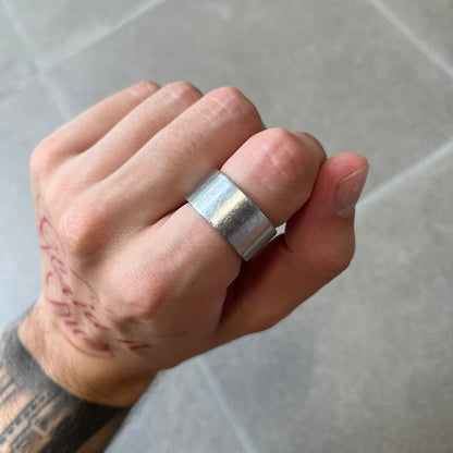 Dolce & Gabbana 2000's Unclassifiable Ring features a minimal stainless steel design with an engraved D&G logo and tilted “Unclassifiable” text underneath on the front. The model number and D&G branding are engraved on the inside.

