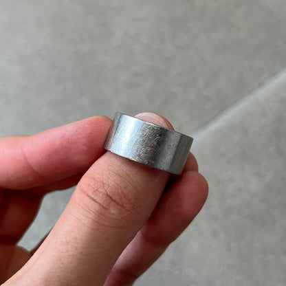 Dolce & Gabbana 2000's Unclassifiable Ring features a minimal stainless steel design with an engraved D&G logo and tilted “Unclassifiable” text underneath on the front. The model number and D&G branding are engraved on the inside.
