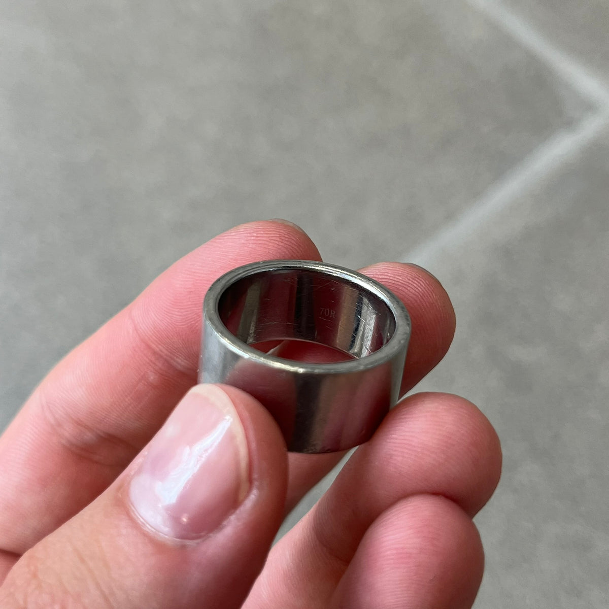Dolce & Gabbana 2000's Unclassifiable Ring features a minimal stainless steel design with an engraved D&G logo and tilted “Unclassifiable” text underneath on the front. The model number and D&G branding are engraved on the inside.
