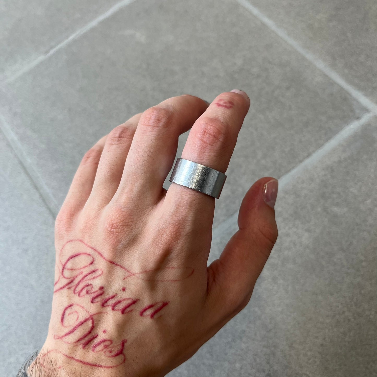 Dolce & Gabbana 2000's Unclassifiable Ring features a minimal stainless steel design with an engraved D&G logo and tilted “Unclassifiable” text underneath on the front. The model number and D&G branding are engraved on the inside.
