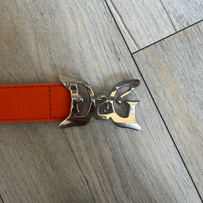 Dolce &amp; Gabbana 2008 Butterfly Buckle Orange Leather Belt from the AW2008 collection. Crafted from smooth orange leather with visible edge stitching, this belt features a big silver-tone D&amp;G logo buckle shaped in a butterfly-style form. The buckle has a polished metal finish, while the belt itself is made from 100% leather and retains a clean, structured profile. An original seasonal accessory from Dolce &amp; Gabbana’s AW2008 season.