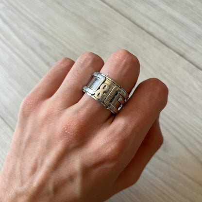 Dolce &amp; Gabbana 3D logo ring crafted in silver-tone metal with a unique two-part construction. The base is a classic band, topped with a raised layer that wraps the D&amp;G logo around the ring. Designed with a movable top section that spins, it’s a dynamic accessory merging playful function with signature branding.