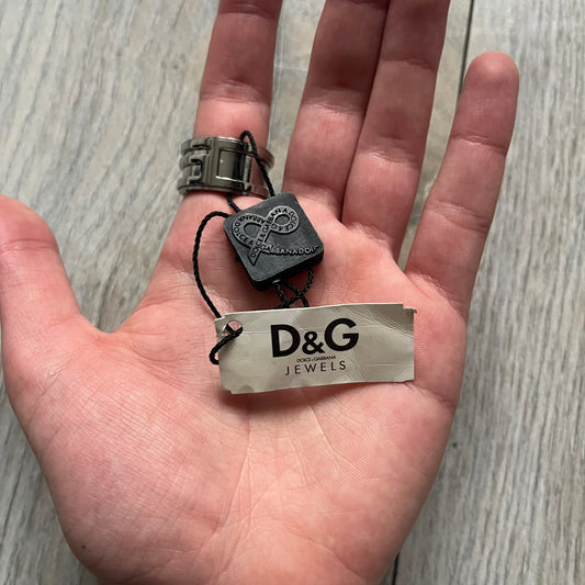 Dolce &amp; Gabbana 3D logo ring crafted in silver-tone metal with a unique two-part construction. The base is a classic band, topped with a raised layer that wraps the D&amp;G logo around the ring. Designed with a movable top section that spins, it’s a dynamic accessory merging playful function with signature branding.