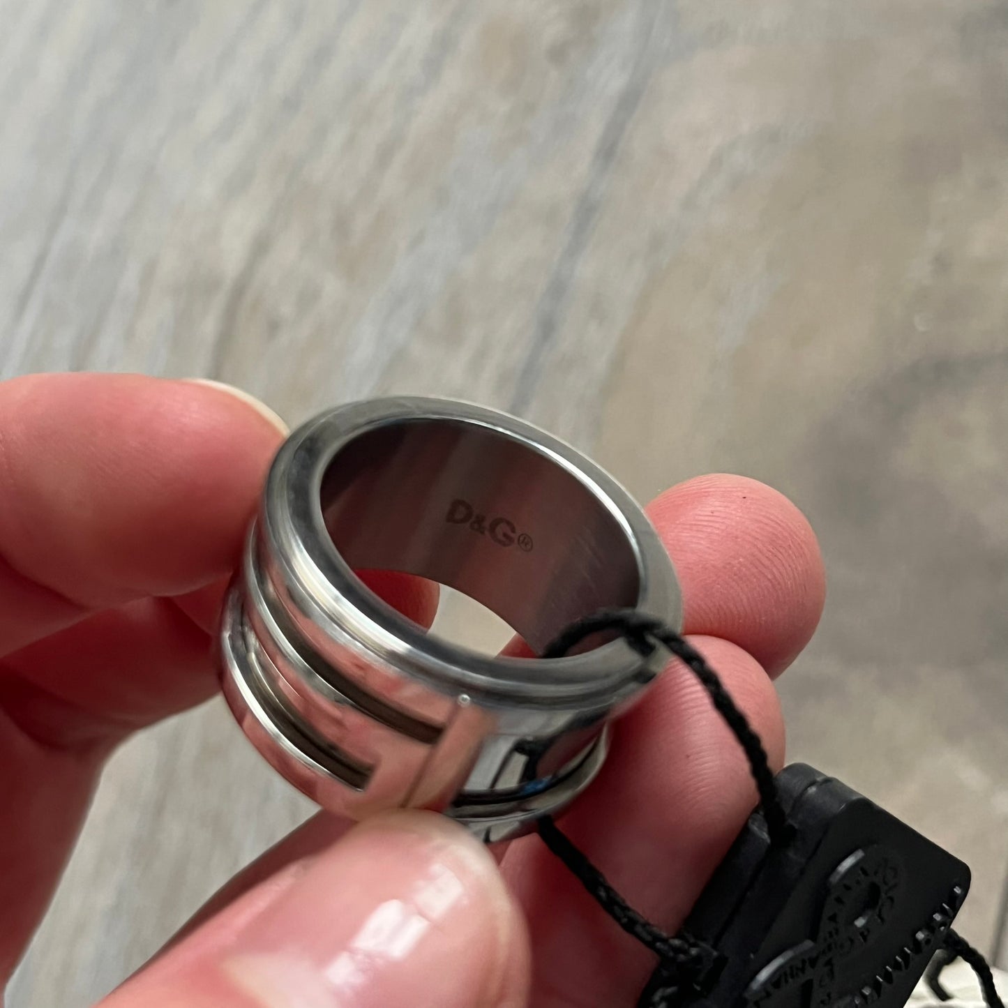 Dolce &amp; Gabbana 3D logo ring crafted in silver-tone metal with a unique two-part construction. The base is a classic band, topped with a raised layer that wraps the D&amp;G logo around the ring. Designed with a movable top section that spins, it’s a dynamic accessory merging playful function with signature branding.